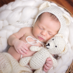 baby with crochet bear and bonnet